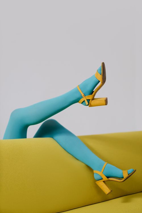 Free Stylish legs in blue tights with yellow shoes, showcasing modern fashion trends. Stock Photo
