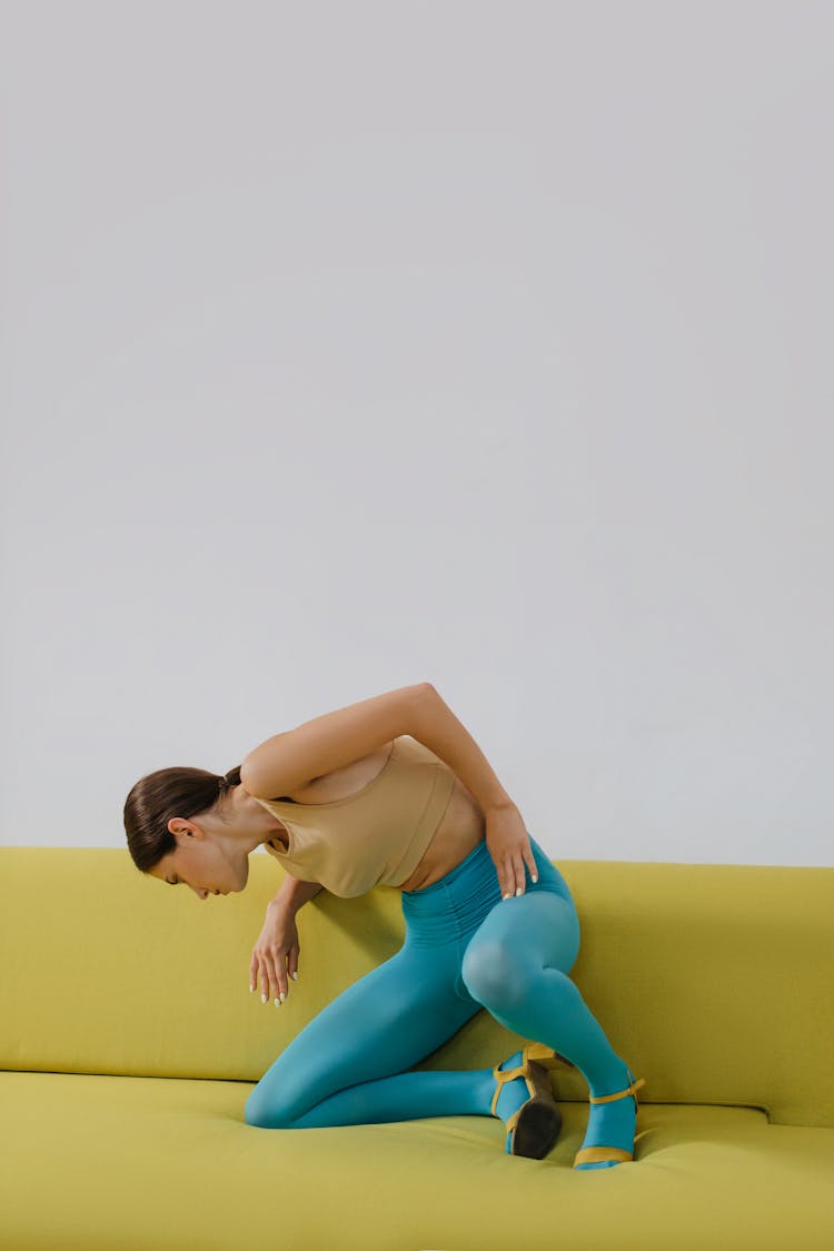 Woman In Blue Leggings Sitting On Couch