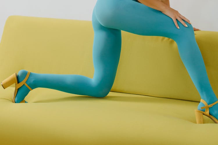 A Person In Teal Leggings On A Yellow Couch