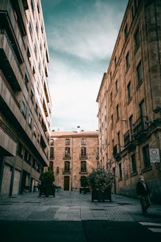 Capture of a tranquil street in Salamanca, Spain showcasing classic architecture and a solitary pedestrian.
