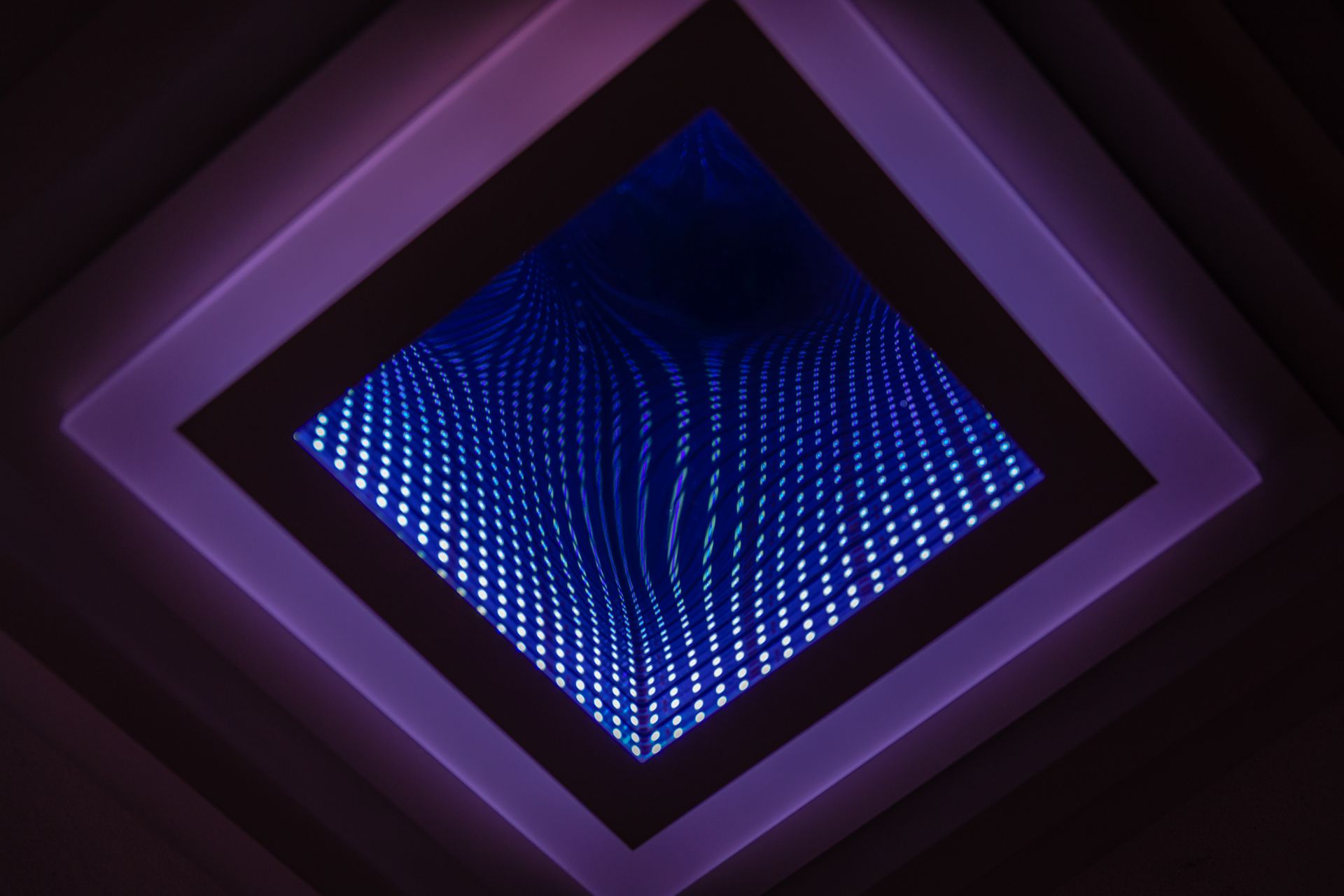 A captivating abstract view of a LED infinity mirror with vibrant light patterns.