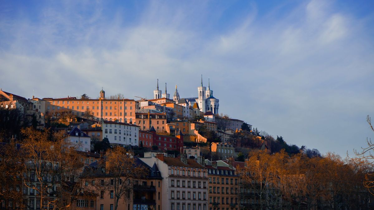 The Basilica of Notre-Dame de Fourviere above the ochre houses of old Lyon in evening light