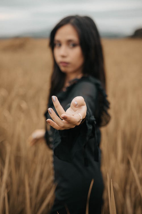 Woman Standing on the Field with Outstretched Arm 