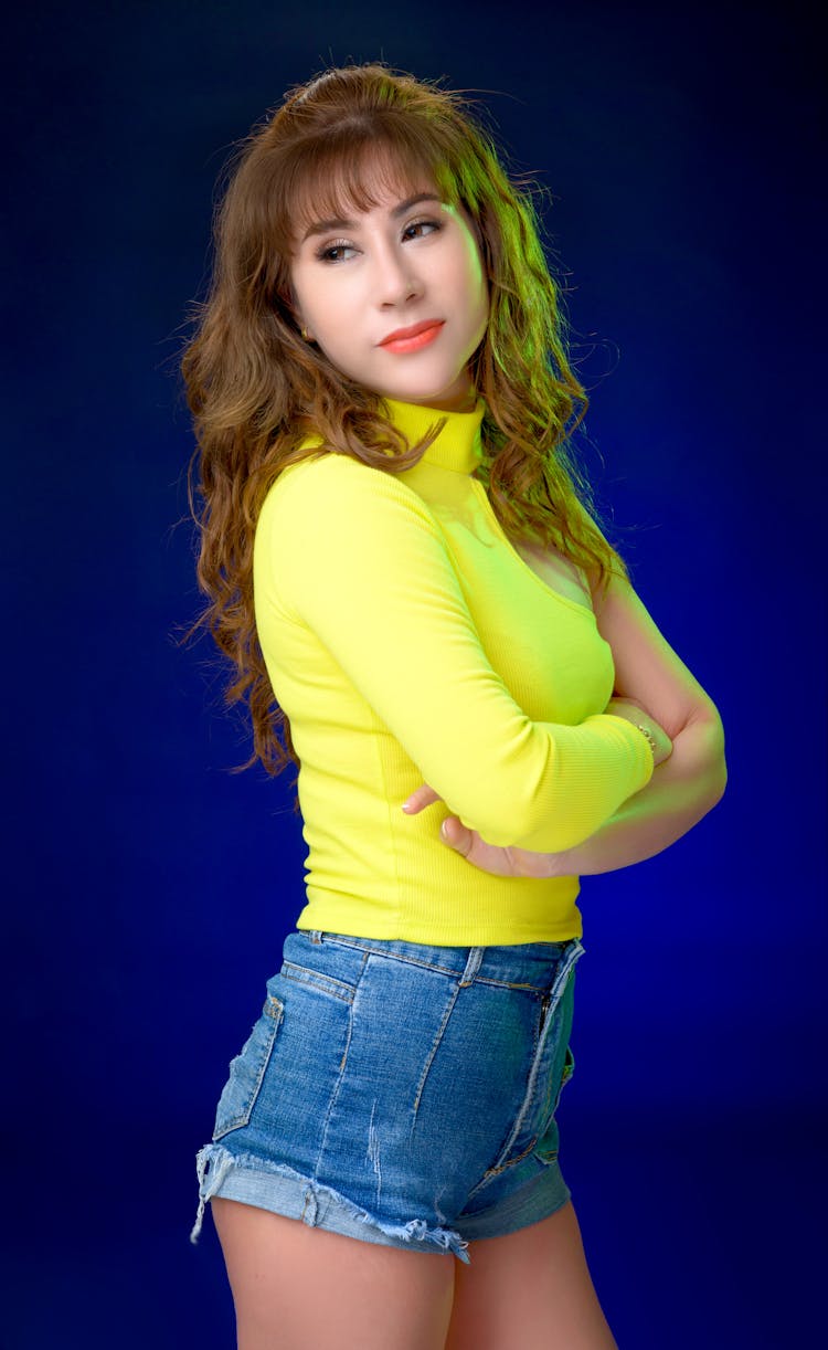 Portrait Of A Woman Wearing Denim Shorts And A Yellow Top