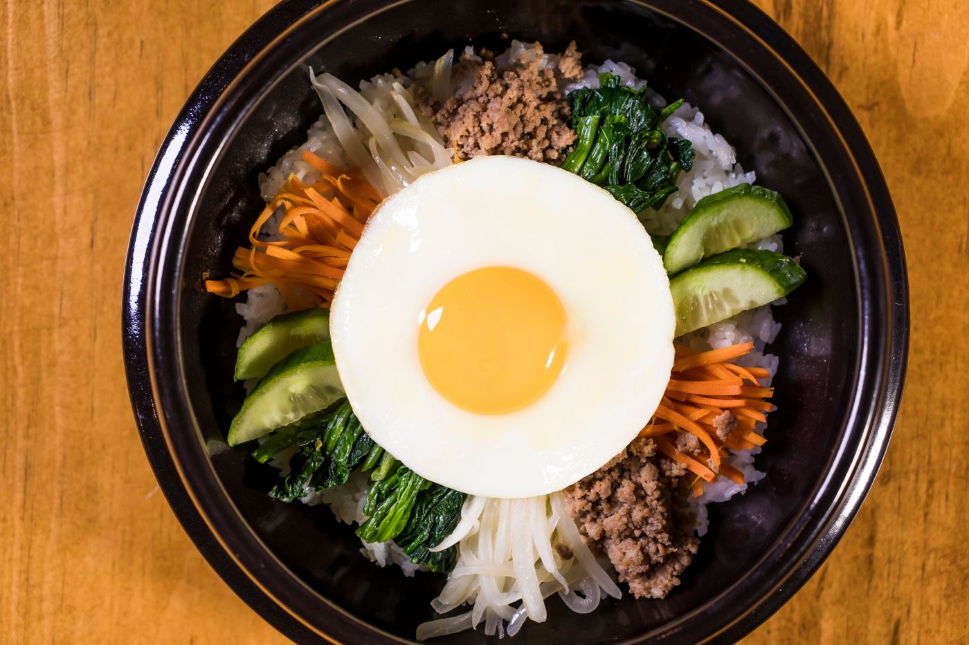 Bibimbap bowl top-down with vegetables and egg