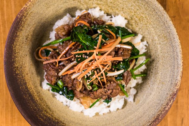 Deliciously vibrant Korean bibimbap topped with marinated bulgogi beef and fresh vegetables.