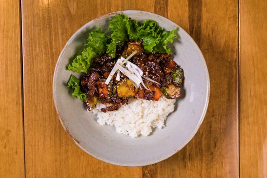 A delicious Korean BBQ rice bowl with fresh lettuce on a rustic wooden table.