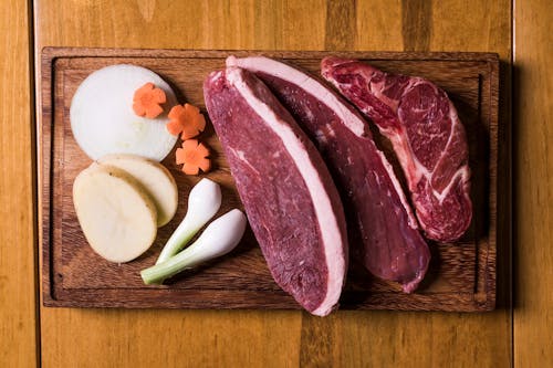 Free Sliced Raw Meat on Brown Wooden Chopping Board Stock Photo