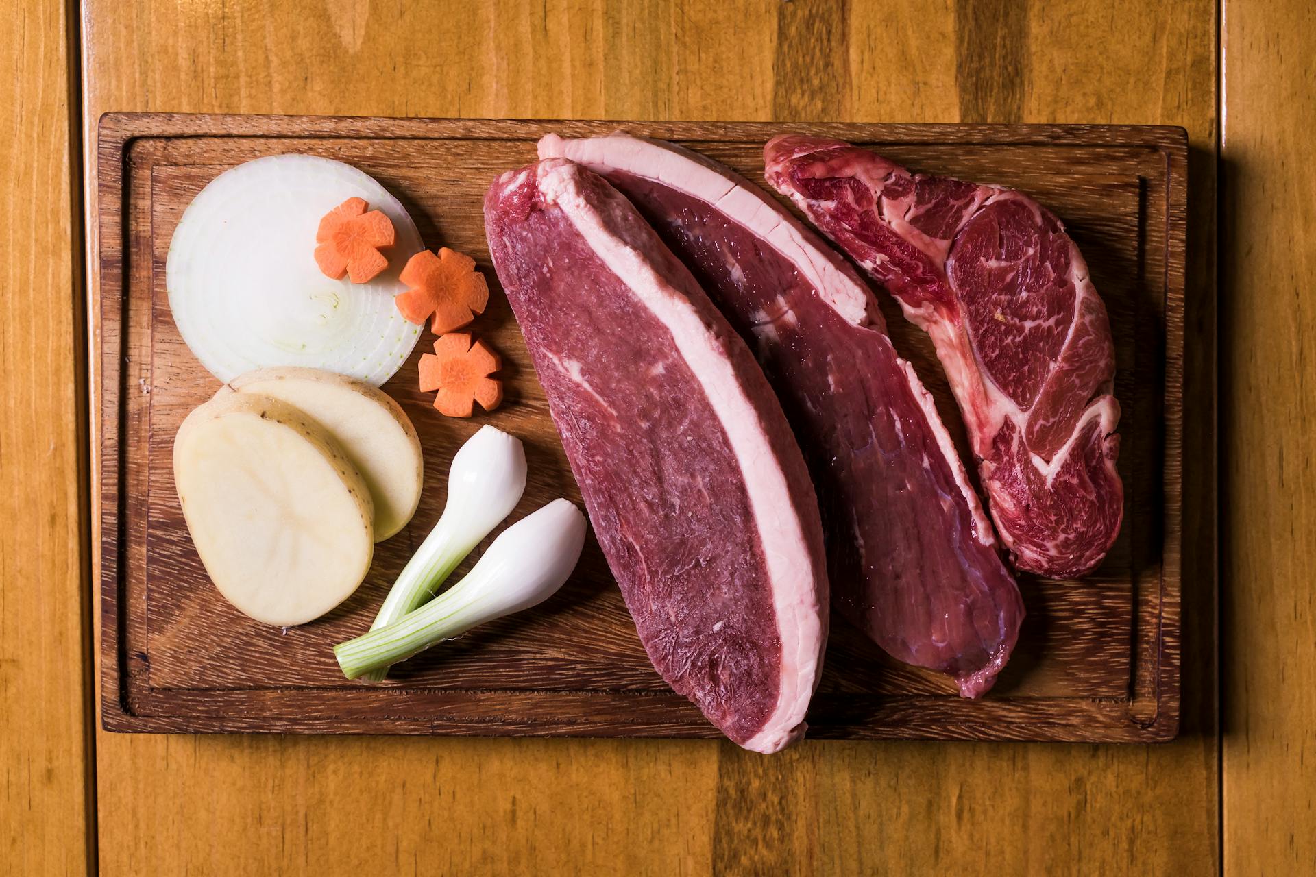 Sliced Raw Meat on Brown Wooden Chopping Board