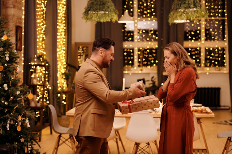 Man Giving Christmas Presents To His Wife