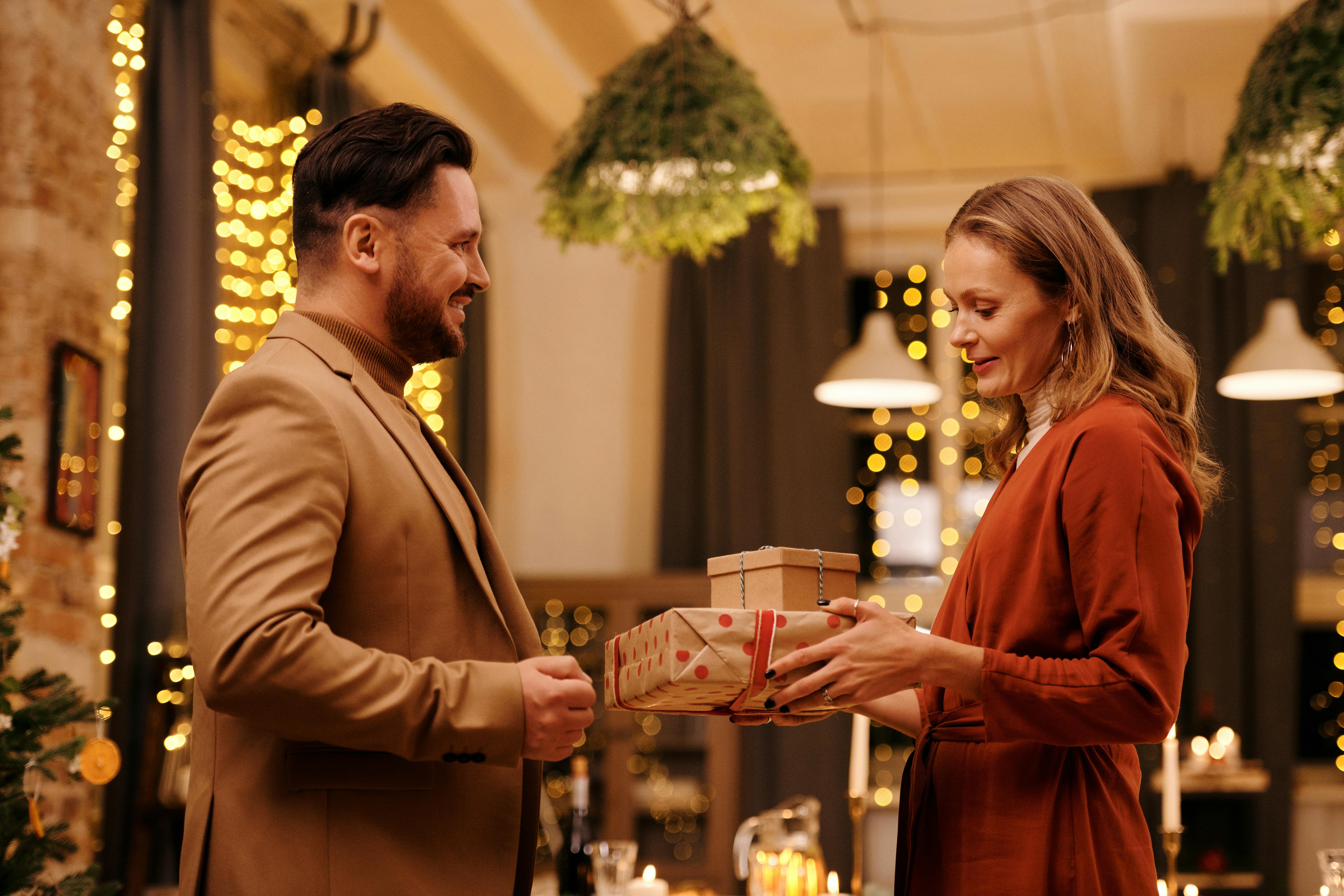 woman giving christmas presents to her husband