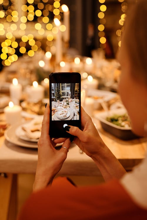 Woman Taking Photo of Food on Table