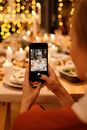 Woman Taking Photo of Food on Table