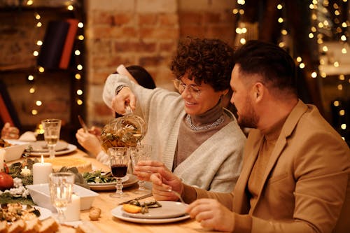 Woman Pouring Drink from a Glass Pitcher to a Drinking Glass