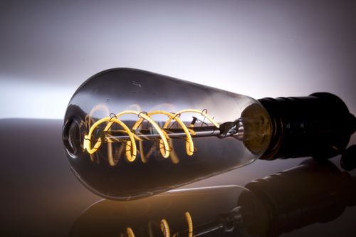 Free Close-up shot of a vintage Edison light bulb with visible filament and reflection. Stock Photo