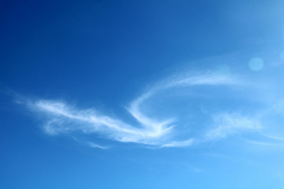 A clear blue sky featuring elegant, wispy cirrus clouds on a sunny day.