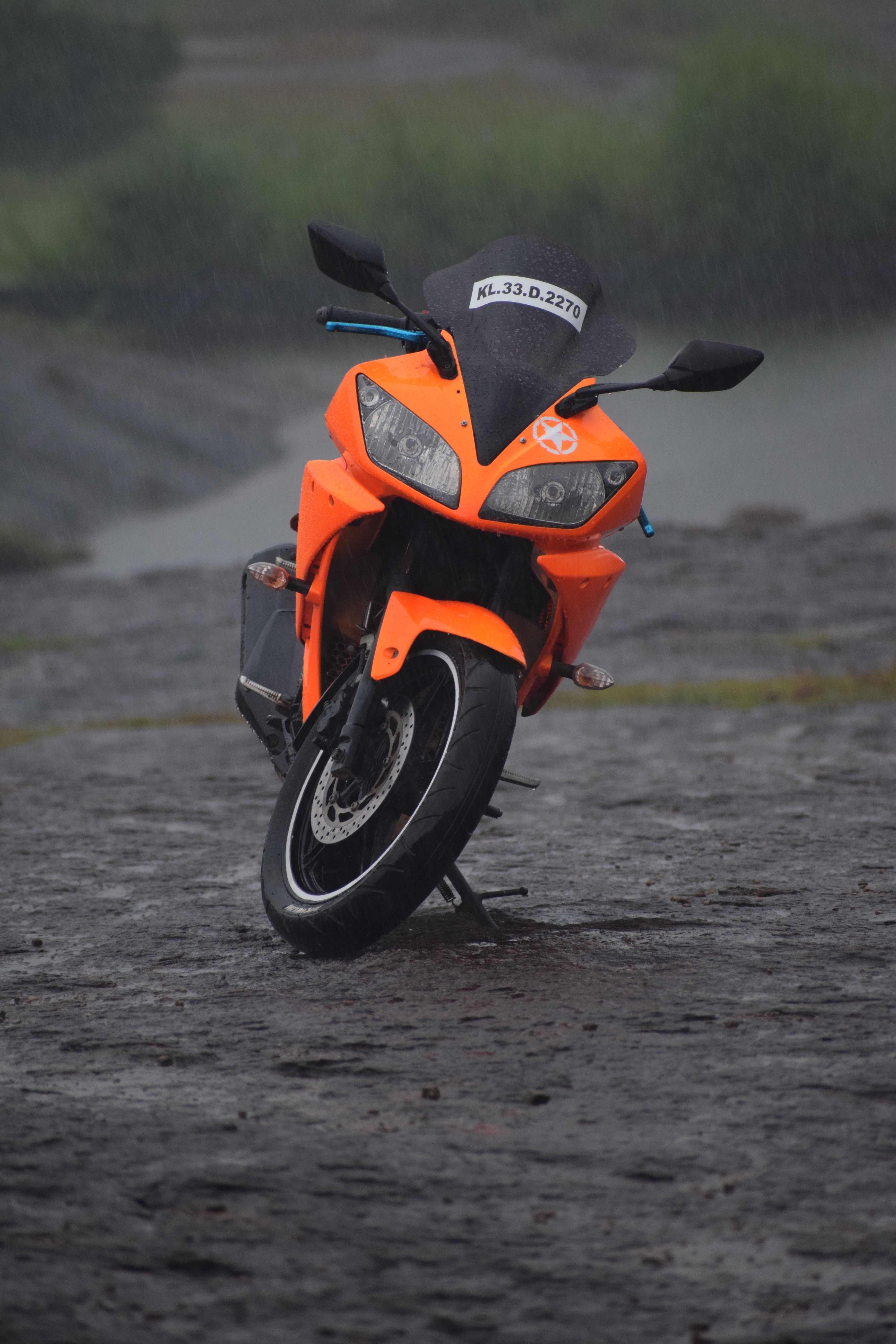 一辆充满活力的橙色运动自行车停在雨天潮湿的土路上
