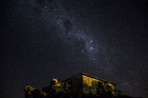 Free A captivating view of the Milky Way over a stone house in São Tomé das Letras, Brazil. Stock Photo