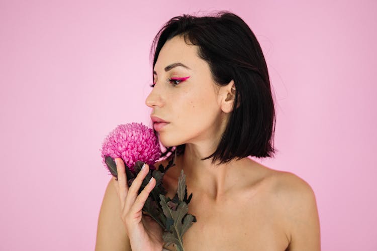 A Portrait Of A Woman Holding A Pink Flower