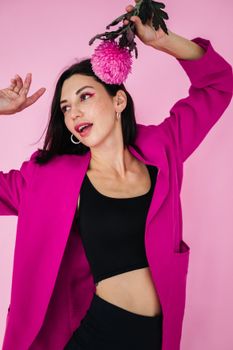 一位身着活力西装的女人与粉红色花朵构成了一幅别致的时尚肖像