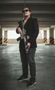 Man in Black Blazer Holding a Assault Riffle
