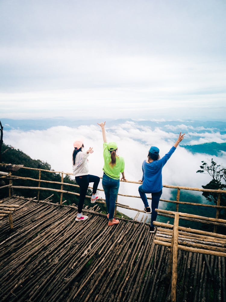 Unrecognizable Women Standing On Viewpoint Against Cloudy Sky