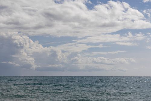 Free Serene ocean view under a vast cloudy sky, perfect for tranquil themes. Stock Photo
