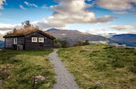 这座田园诗般的乡村小屋，草屋顶与壮丽的山景相得益彰