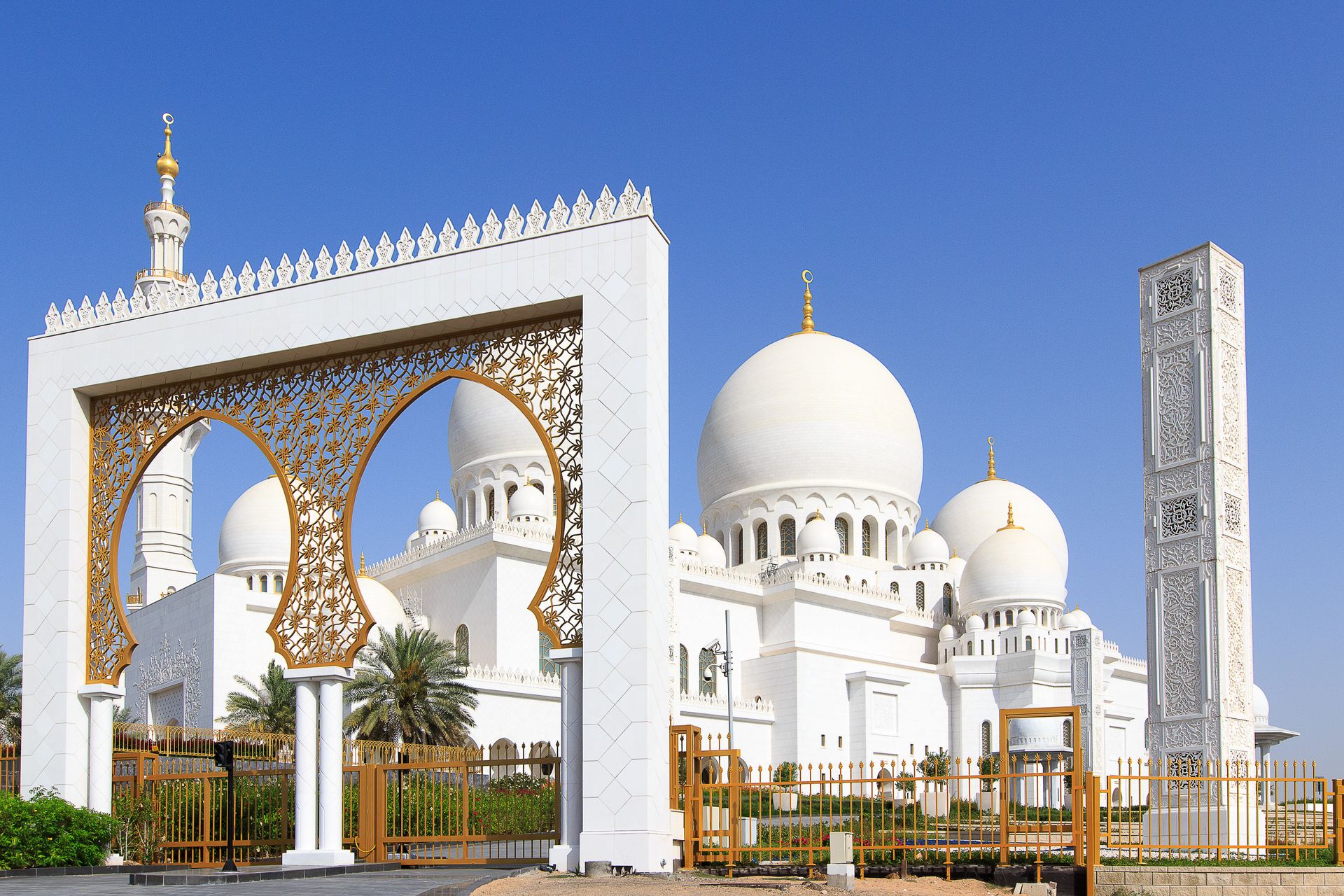 Elegant architecture of Sheikh Zayed Grand Mosque in Abu Dhabi with clear blue sky.