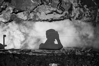 Faceless photographer taking photo of puddle between dirt on camera