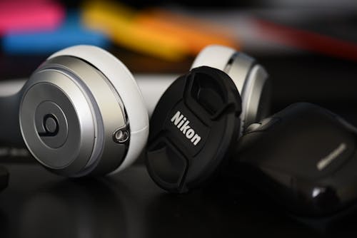 Free Silver Beats by Dr. Dre Studio and Nikon Camera Lens Cover Stock Photo