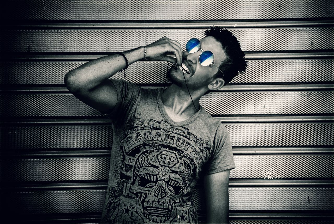 fashionable man modeling sunglasses in an edgy urban setting
