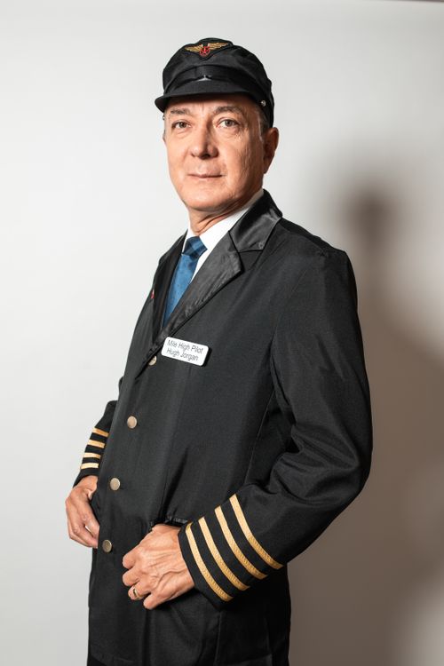 Free A professional airline pilot posing confidently in uniform against a neutral background. Stock Photo