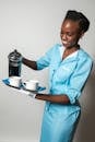Woman in a Uniform Pouring Coffee
