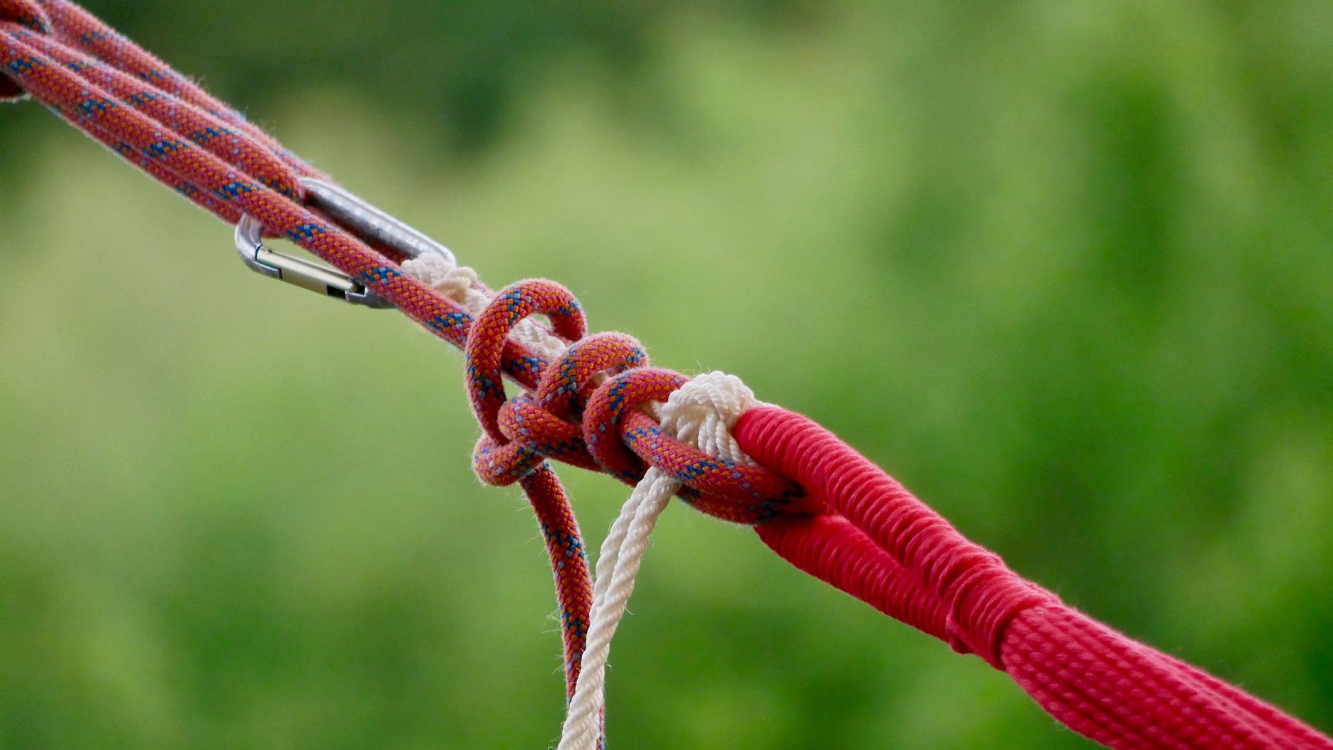 Detailed view of a climbing knot with ropes and carabiner outdoors