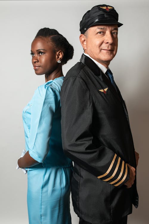 Homem De Jaqueta Preta E Amarela Ao Lado De Uma Mulher De Vestido Azul