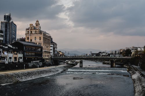 Braunes Betongebäude Nahe Fluss Unter Weißen Wolken