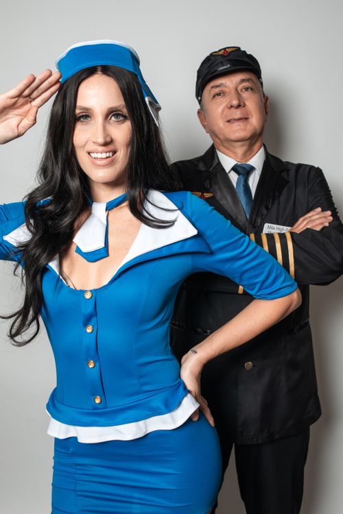 Free Portrait of a smiling flight attendant and pilot in uniforms posing confidently against a white background. Stock Photo