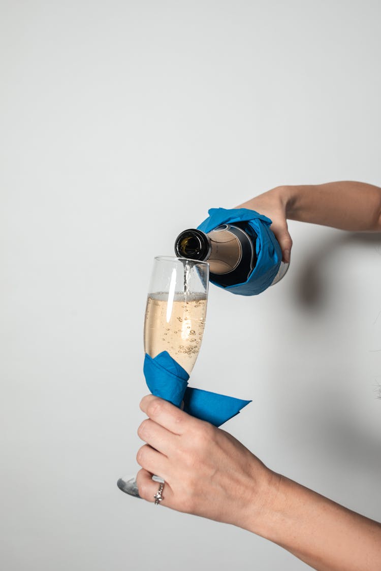 Photograph Of A Person Pouring Champagne Into A Glass