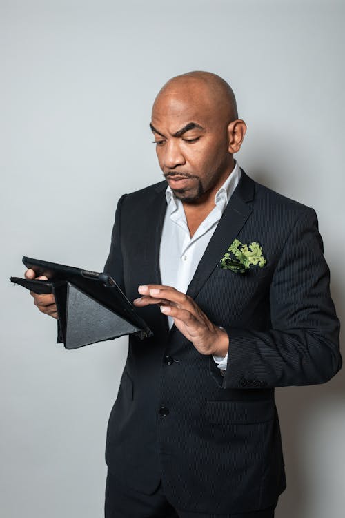 A Man in Black Suit Jacket Using a Black Tablet