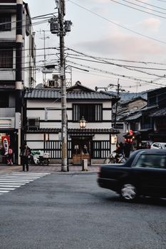 黄昏时分，日本京都繁华的街道上，传统建筑与过往车辆相映成趣