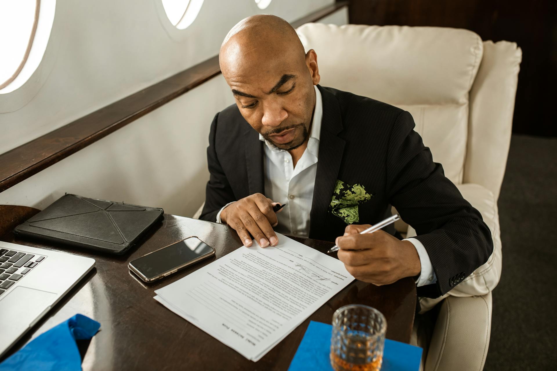 An executive working on documents in a luxurious private jet interior.