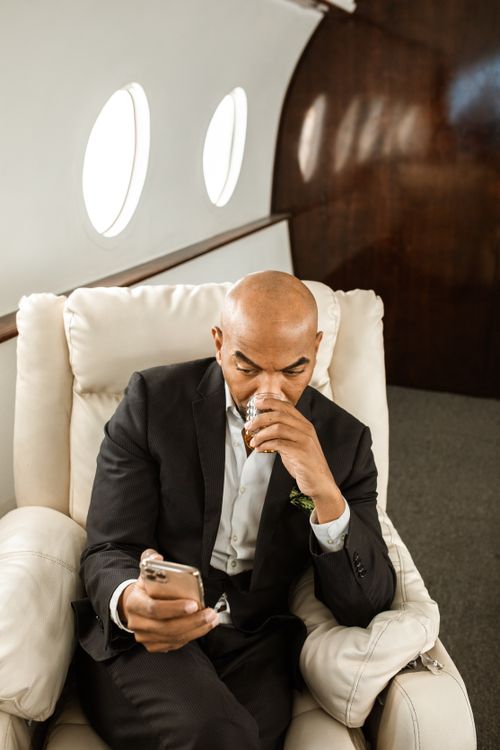 Free Man relaxing in a luxurious private jet, enjoying the elite travel experience. Stock Photo