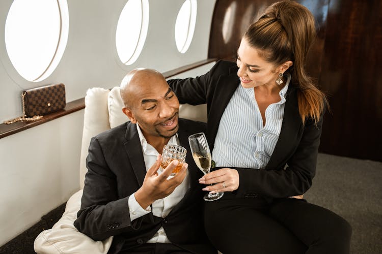 A Couple Holding Glasses With Wine