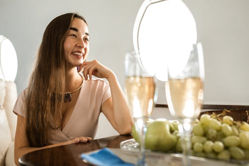 椅子に座っている白いスパゲッティストラップトップの女性