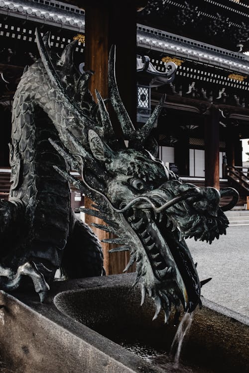 бесплатная Статуя черного дракона возле коричневого здания Стоковое фото