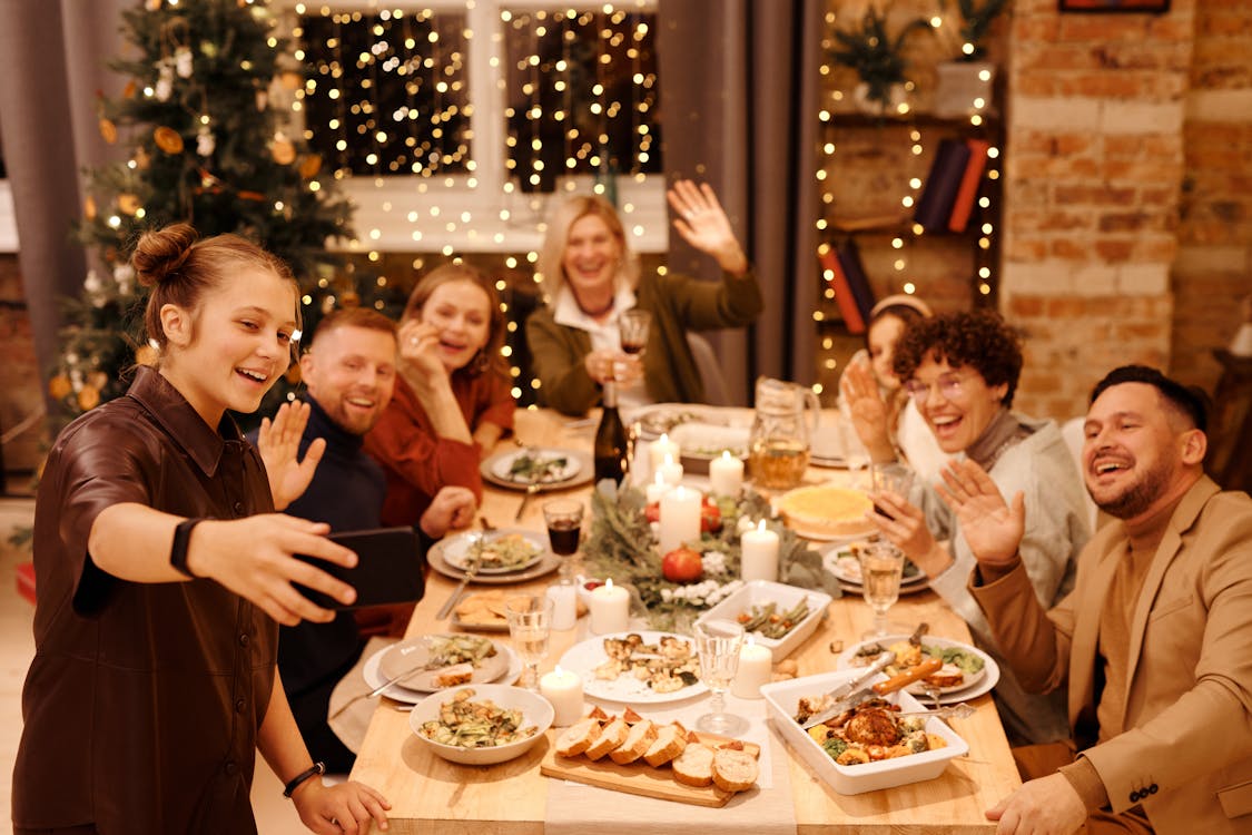 Free Family Celebrating Christmas Dinner While Taking Selfie Stock Photo