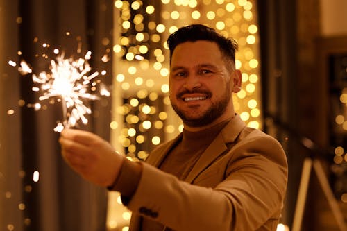 Homem De Casaco Marrom Sorrindo Enquanto Segura Um Diamante Aceso