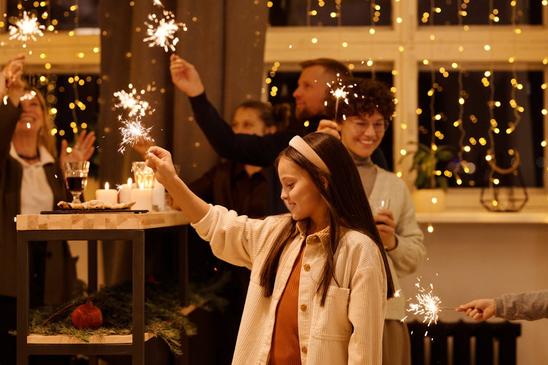 Family Celebrating Christmas While Holding Burning Sparklers