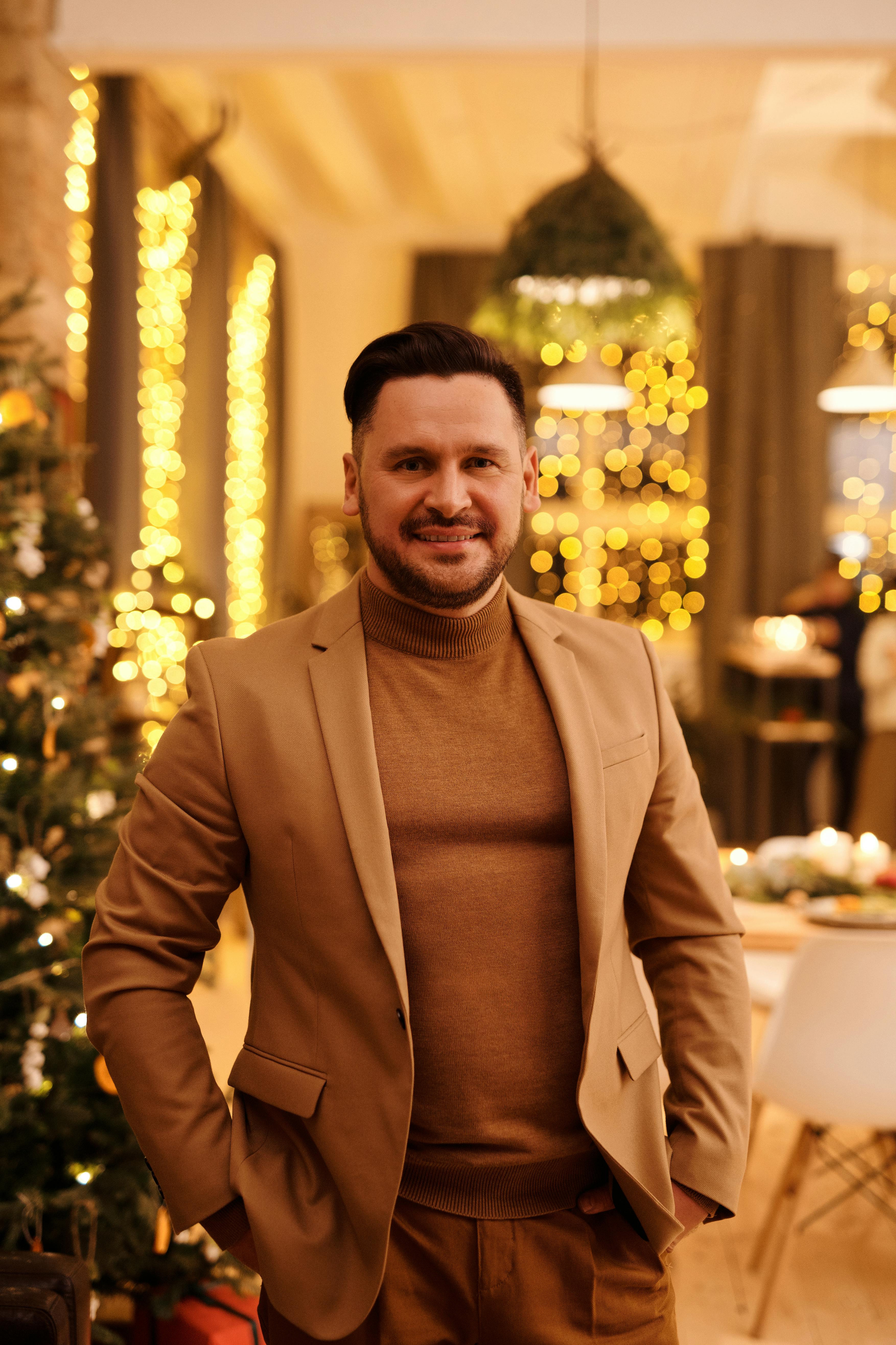 man in brown blazer smile while looking at the camera